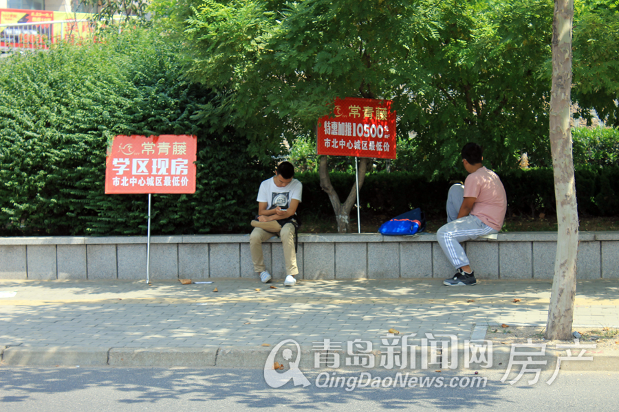 正午烈日当头 绍兴路北端两位楼盘工作宣传人员在树下休息